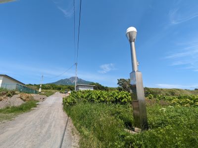 利尻山を背景に電子基準点「利尻」を見る