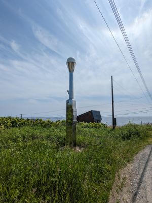日本海を背景に電子基準点「利尻」を見る