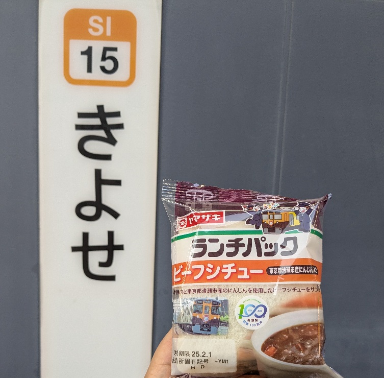 ランチパック「ビーフシチュー（清瀬市産にんじん入り）」を清瀬駅の駅名標示と共に撮影した写真