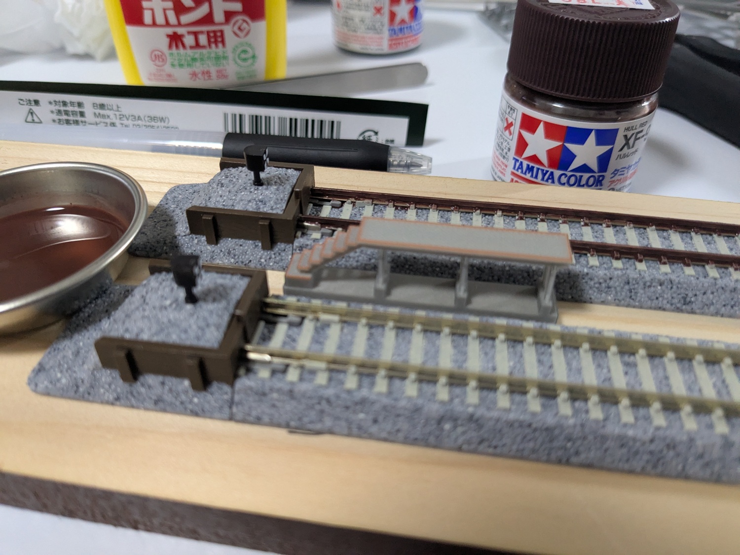 塗装作業中の写真。複線の内、片方は錆鉄色に塗られているが、もう片方は未塗装である