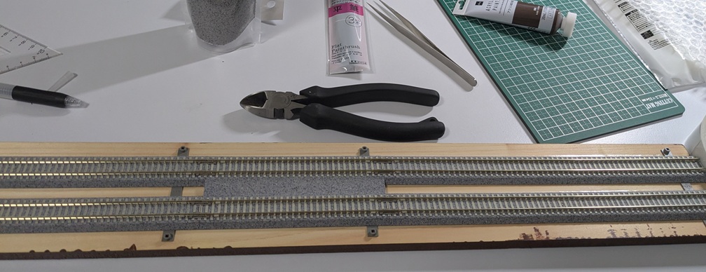 未塗装の基礎板の上にレールが仮置きされている状態