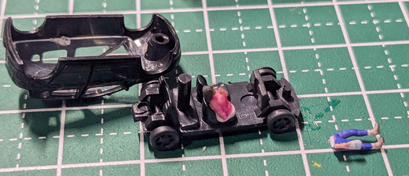 乗用車を分解して人形を乗せて接着している作業途中の写真