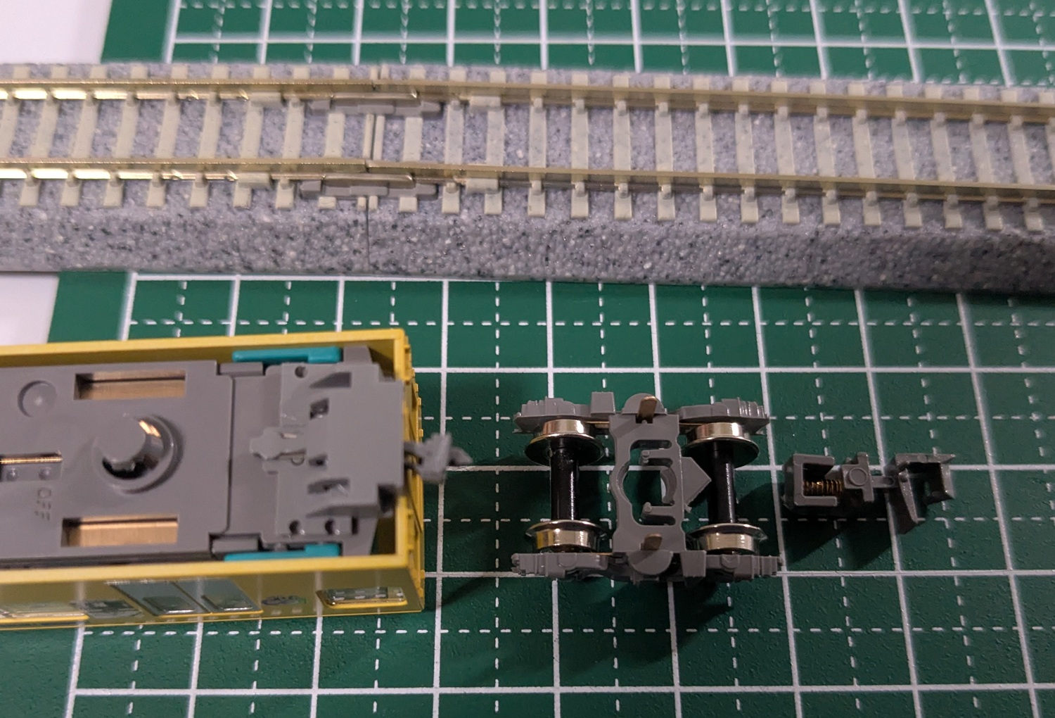 裏返しにされた模型車両の連結器の写真