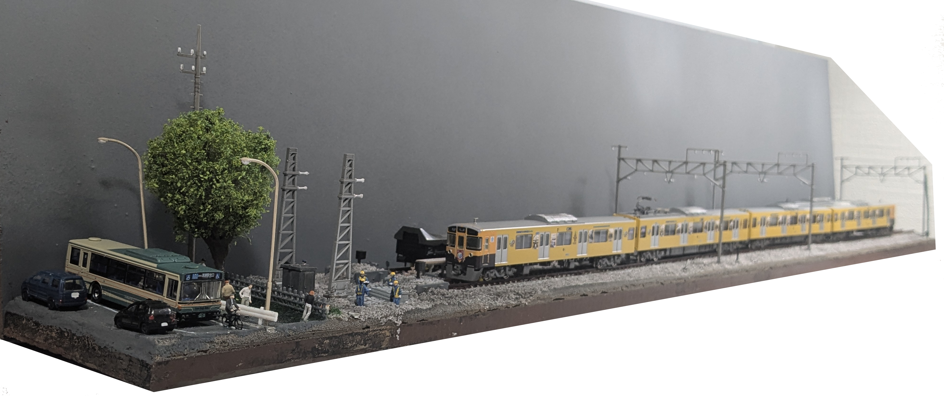 完成状態のレイアウト全景。手前に道路の情景があり、線路の車止めの奥に記念トレインが4両編成になって留置されている